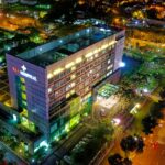 Stunning aerial view of Eka Hospital in Serpong, Indonesia, illuminated at night, capturing vibrant city lights and architecture.